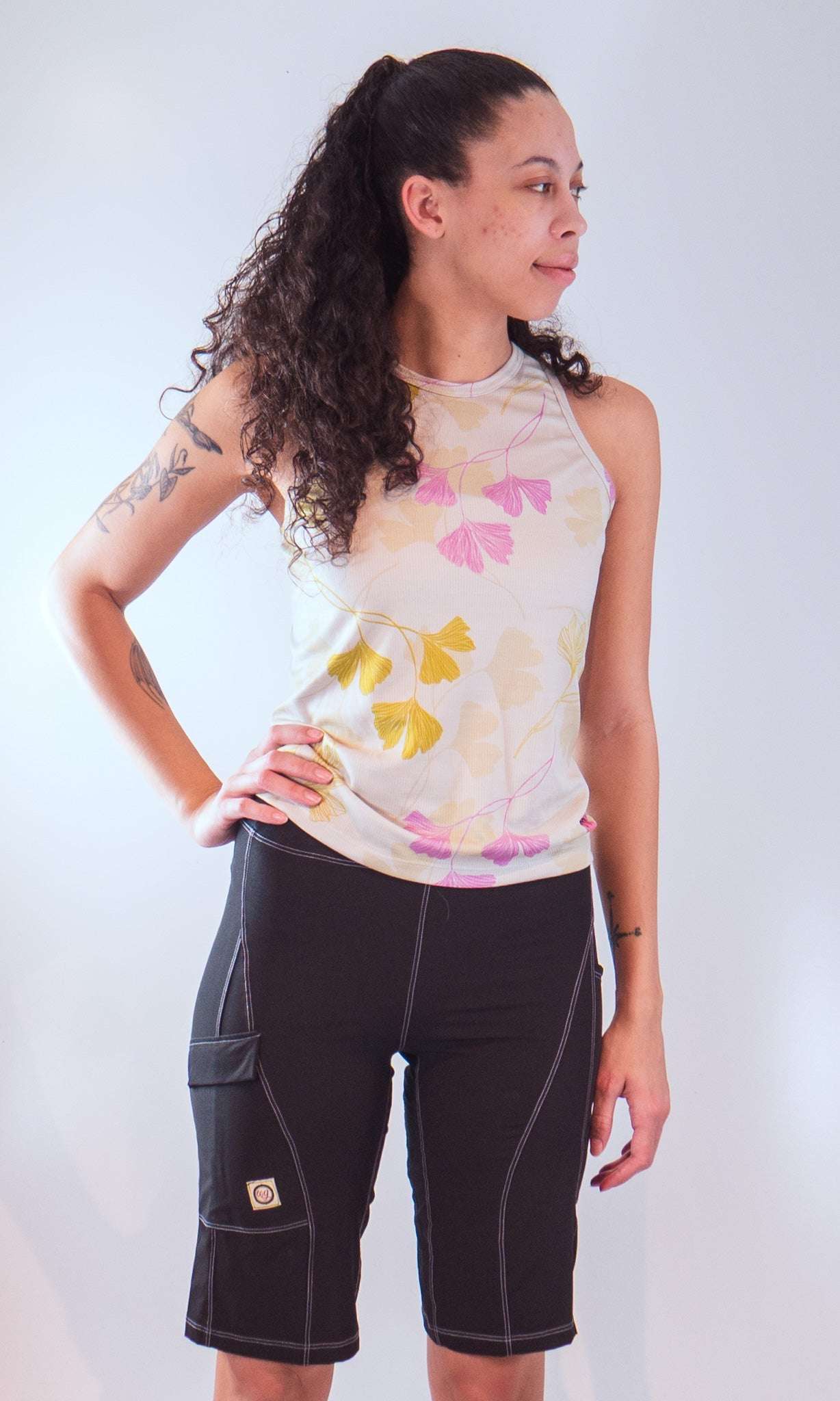 Women's sleeveless bike jersey with floral design, featuring breathable mesh fabric and back pocket.